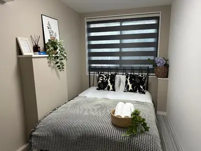 a bedroom with a bed with black and white pillows and a window at COMMA HOUSE Shinjuku 11 in Tokyo