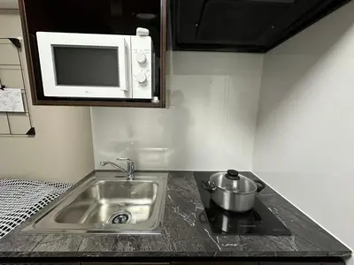 a kitchen counter with a sink and a microwave at COMMA HOUSE Shinjuku 11 in Tokyo