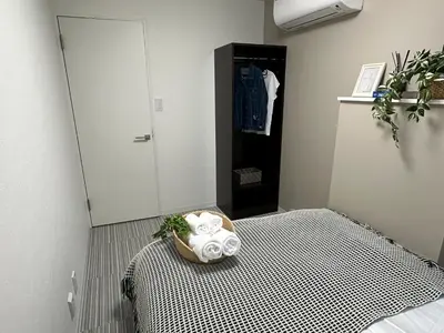 a bedroom with a bed with a black and white pattern at COMMA HOUSE Shinjuku 11 in Tokyo