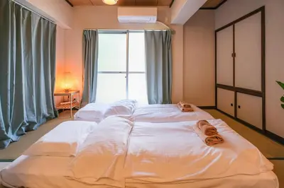 two beds in a room with a large window at Mi-APT TAKINO in Tokyo
