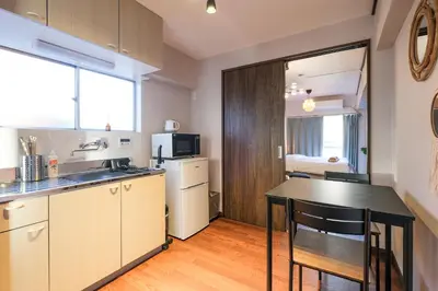 a kitchen with a counter and a table in a room at Mi-APT TAKINO in Tokyo