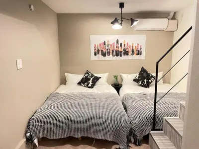 two beds in a small room with a staircase at COMMA HOUSE Shinjuku 12 in Tokyo