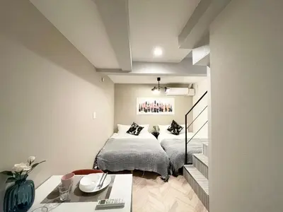 a bedroom with a bed and a table in a room at COMMA HOUSE Shinjuku 12 in Tokyo