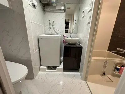a white bathroom with a sink and a toilet at COMMA HOUSE Shinjuku 12 in Tokyo