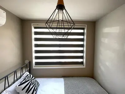 a bedroom with a window with a bed and a lamp at COMMA HOUSE Shinjuku 12 in Tokyo