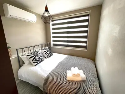 a bedroom with a bed with two pillows and a window at COMMA HOUSE Shinjuku 12 in Tokyo