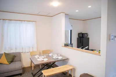 a living room with a table and a couch at \u30b9\u30ab\u30a4\u30c4\u30ea\u30fc\u524d\u62bc\u4e0a\u99c5\u65b0\u7bc9\u30f4\u30a3\u30e9\u7a7a\u6e2f\u76f4\u901a in Tokyo