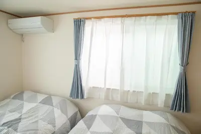 a bedroom with two beds and a window at \u30b9\u30ab\u30a4\u30c4\u30ea\u30fc\u524d\u62bc\u4e0a\u99c5\u65b0\u7bc9\u30f4\u30a3\u30e9\u7a7a\u6e2f\u76f4\u901a in Tokyo