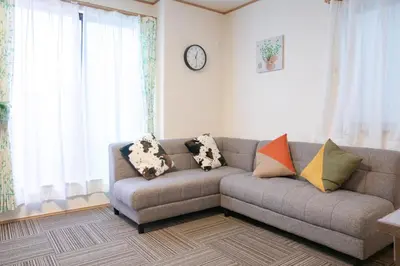 a living room with a couch with pillows on it at \u30b9\u30ab\u30a4\u30c4\u30ea\u30fc\u524d\u62bc\u4e0a\u99c5\u65b0\u7bc9\u30f4\u30a3\u30e9\u7a7a\u6e2f\u76f4\u901a in Tokyo
