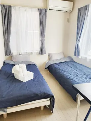 a bedroom with two beds and a chair in it at OHANA TOKYO HOUSE - Vacation STAY 67721v in Tokyo