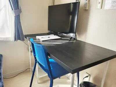 a desk with a computer monitor and a blue chair at OHANA TOKYO HOUSE - Vacation STAY 67721v in Tokyo