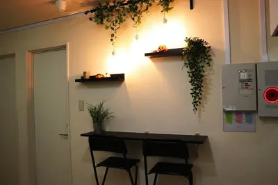 a kitchen with a counter with chairs and plants on the wall at OHANA TOKYO HOUSE - Vacation STAY 67721v in Tokyo
