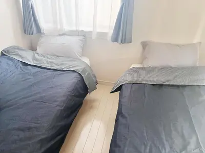 two beds sitting next to a window in a bedroom at OHANA TOKYO HOUSE - Vacation STAY 67721v in Tokyo