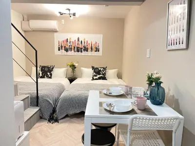 a small room with two beds and a table at COMMA HOUSE Shinjuku 13 in Tokyo
