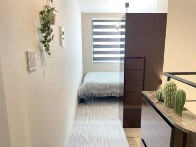 a hallway with a room with a bed and a window at COMMA HOUSE Shinjuku 13 in Tokyo