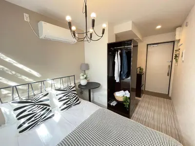 a bedroom with a bed and a chandelier at COMMA HOUSE Shinjuku 13 in Tokyo
