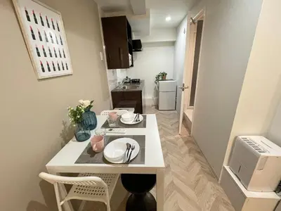 a small kitchen with a white table in a room at COMMA HOUSE Shinjuku 13 in Tokyo
