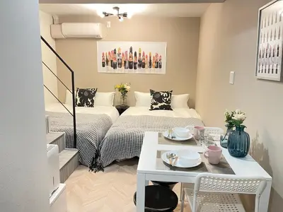 a small room with two beds and a table at COMMA HOUSE Shinjuku 13 in Tokyo