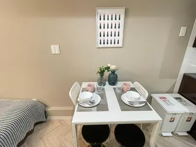 a white dining room table with two chairs and flowers at COMMA HOUSE Shinjuku 13 in Tokyo