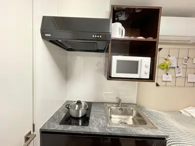 a small kitchen with a sink and a microwave at COMMA HOUSE Shinjuku 14 in Tokyo