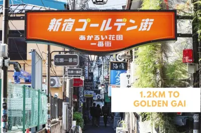 an orange sign on a city street with signs at COMMA HOUSE Shinjuku 14 in Tokyo