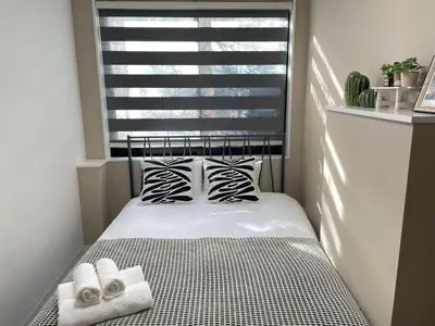 a small bedroom with a bed in front of a window at COMMA HOUSE Shinjuku 14 in Tokyo