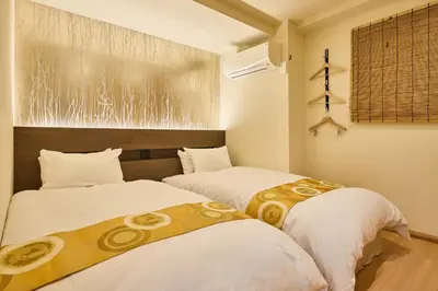 two beds in a room with white and gold sheets at KEYAKIAN Tokyo Nihonbashi in Tokyo