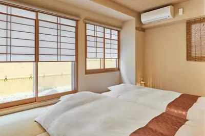 a bedroom with a bed and a large window at KEYAKIAN Tokyo Nihonbashi in Tokyo