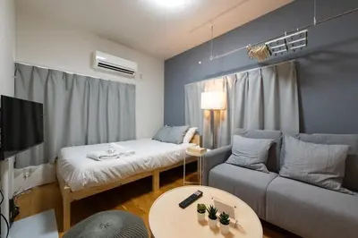 a living room with a couch and a table at \u30a2\u30f3\u30c9\u30b9\u30c6\u30a4\u8db3\u7acb2\u4e01\u76ee202 Soi house in Tokyo