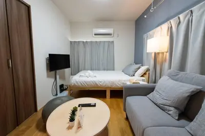 a small living room with a couch and a bed at \u30a2\u30f3\u30c9\u30b9\u30c6\u30a4\u8db3\u7acb2\u4e01\u76ee202 Soi house in Tokyo