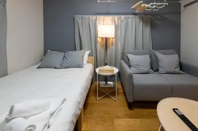 a room with two beds and a couch and a table at \u30a2\u30f3\u30c9\u30b9\u30c6\u30a4\u8db3\u7acb2\u4e01\u76ee202 Soi house in Tokyo