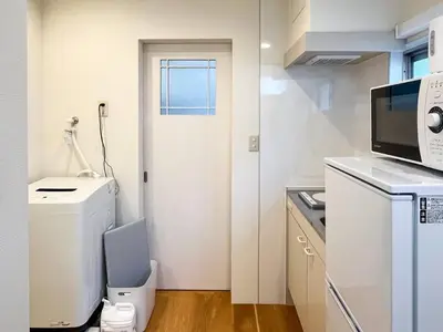 a small kitchen with a toilet and a door at \u30a2\u30f3\u30c9\u30b9\u30c6\u30a4\u8db3\u7acb2\u4e01\u76ee202 Soi house in Tokyo