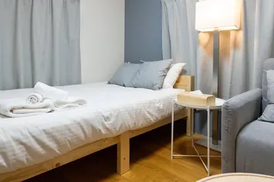 a bed in a room with a lamp and a chair at \u30a2\u30f3\u30c9\u30b9\u30c6\u30a4\u8db3\u7acb2\u4e01\u76ee202 Soi house in Tokyo
