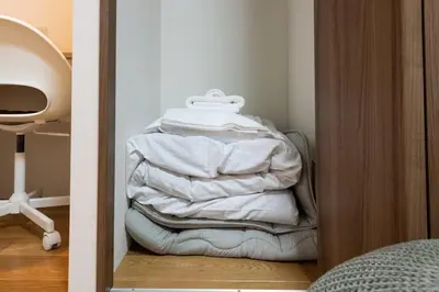 a stack of white towels sitting in a closet at \u30a2\u30f3\u30c9\u30b9\u30c6\u30a4\u8db3\u7acb2\u4e01\u76ee202 Soi house in Tokyo