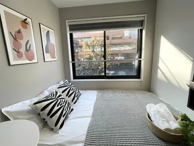 a bedroom with a bed with two pillows and a window at COMMA HOUSE Shinjuku301 in Tokyo