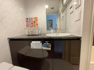 a bathroom with a counter with a sink and a mirror at COMMA HOUSE Shinjuku301 in Tokyo