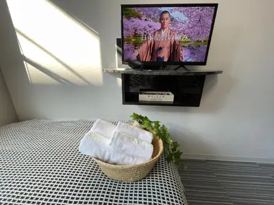 a bedroom with a bed with a tv on the wall at COMMA HOUSE Shinjuku301 in Tokyo