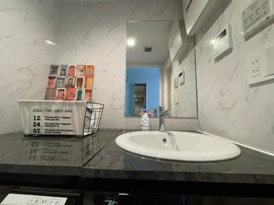 a bathroom with a sink and a mirror at COMMA HOUSE Shinjuku301 in Tokyo