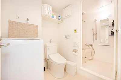 a white bathroom with a toilet and a shower at Toggle\u30a2\u30d1\u30fc\u30c8\u83ca\u5ddd\u99c5\u304b\u3089\u5f92\u6b69 in Tokyo
