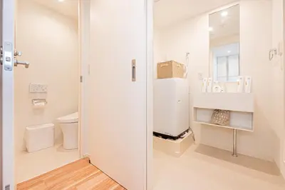a white bathroom with a sink and a refrigerator at Toggle\u30a2\u30d1\u30fc\u30c8\u83ca\u5ddd\u99c5\u304b\u3089\u5f92\u6b69 in Tokyo