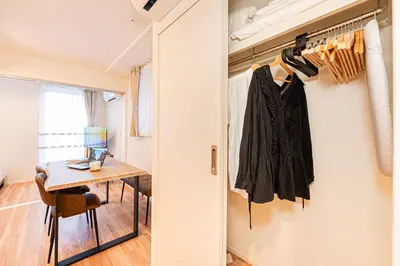 a hallway with a door leading into a room with a table at Toggle\u30a2\u30d1\u30fc\u30c8\u83ca\u5ddd\u99c5\u304b\u3089\u5f92\u6b69 in Tokyo