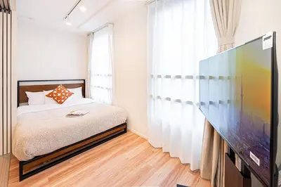 a bedroom with a bed and a flat screen tv at Toggle\u30a2\u30d1\u30fc\u30c8\u83ca\u5ddd\u99c5\u304b\u3089\u5f92\u6b69 in Tokyo
