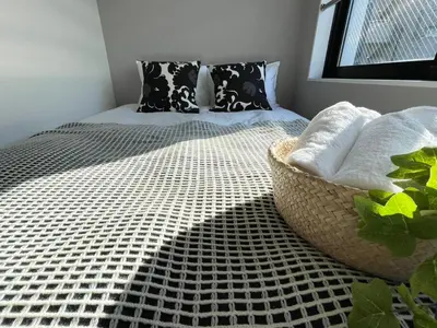 a bed with black and white sheets and pillows at COMMA HOUSE Shinjuku302 in Tokyo