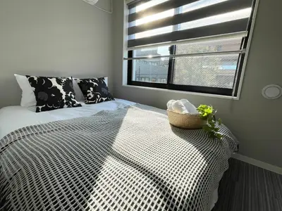 a bedroom with a bed and a window with a basket on it at COMMA HOUSE Shinjuku302 in Tokyo