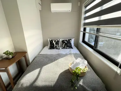 a small bedroom with a bed and a window at COMMA HOUSE Shinjuku302 in Tokyo