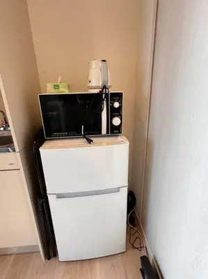 a microwave sitting on top of a white refrigerator at \u68ee\u4e0b\u99c52\u5206\u4e21\u56fd\u99c57\u5206Skytreeview401 in Tokyo