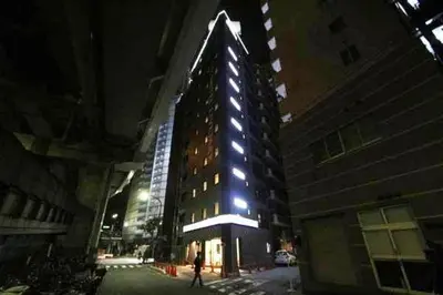 a tall building with lights on it at night at HOTEL LiVEMAX Nihonbashi Hakozaki in Tokyo