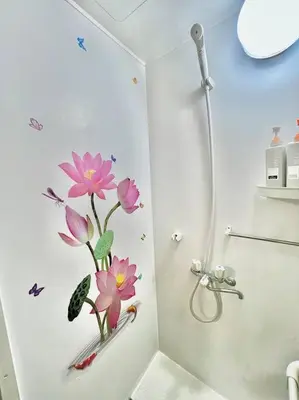 a bathroom with a shower with pink flowers on the wall at \u4e0a\u91ce\u516c\u56ed\u65c1\u65e5\u5f0f\u6c11\u5bbf3 in Tokyo
