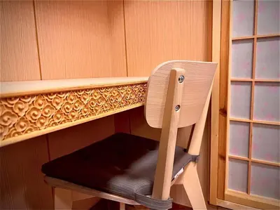 a wooden chair sitting under a shelf in a room at \u4e0a\u91ce\u516c\u56ed\u65c1\u65e5\u5f0f\u6c11\u5bbf3 in Tokyo