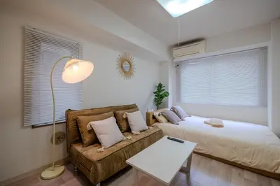 a bedroom with a bed and a couch at #8 -\u30a2\u30a4\u30e0\u30bf\u30a6\u30f3\u5357\u845b\u897f- Entire Unit in Tokyo